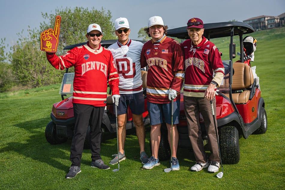 Image of our 2023 DU Spirit Team Winners. Four golfers standing in front of a golf cart.